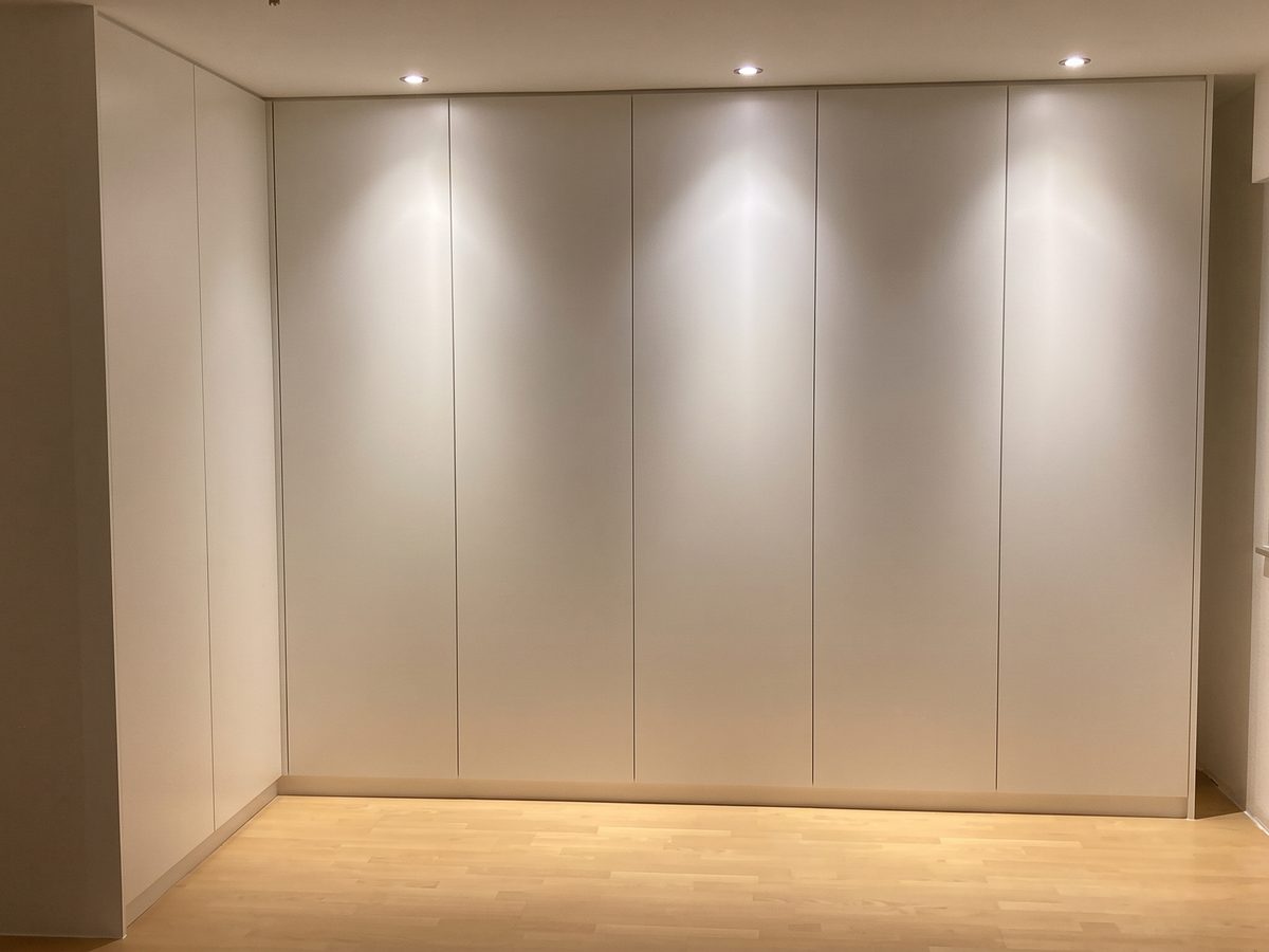 Raumhohe weiße Schrankwand mit Deckenspots